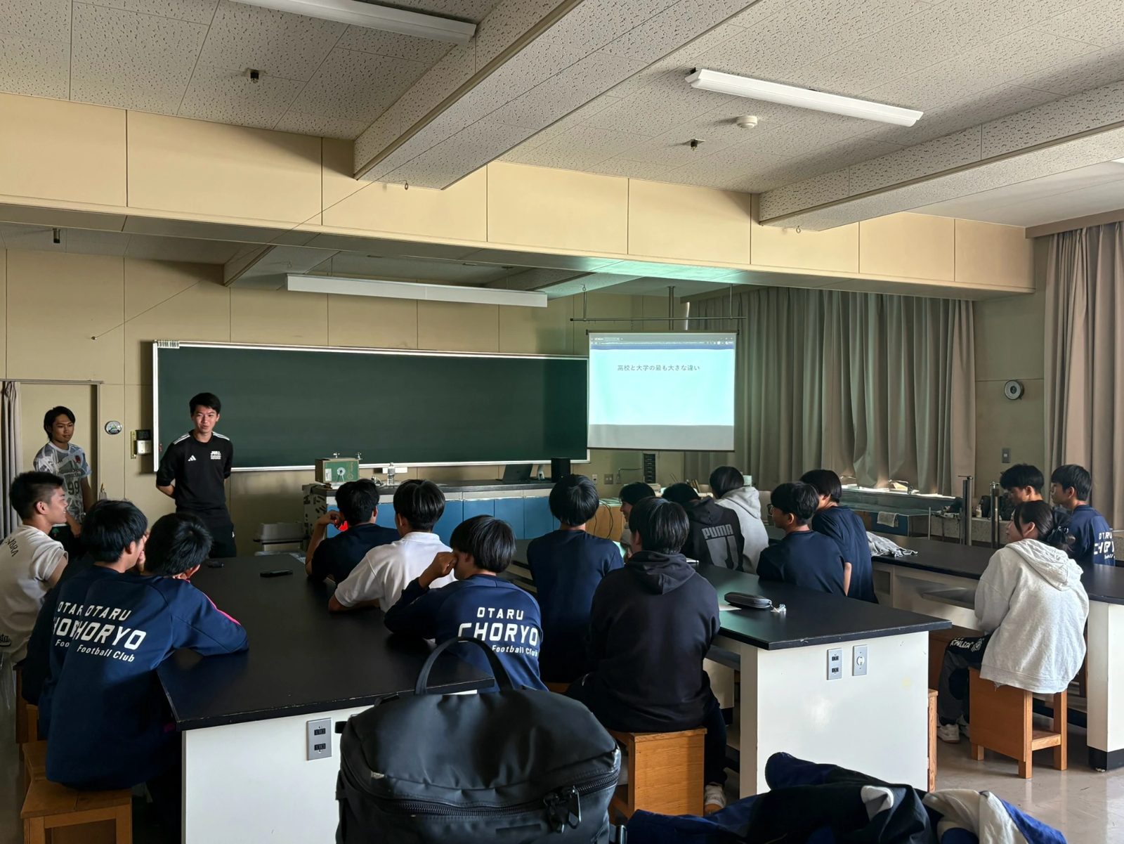 「高校と大学の最も大きな違い」について話す森さんと聴講する潮陵高校サッカー部の生徒たち